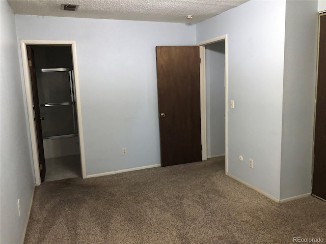 unfurnished bedroom featuring a textured ceiling and carpet floors