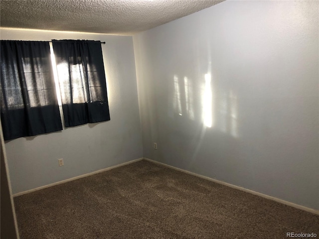 carpeted spare room featuring a textured ceiling