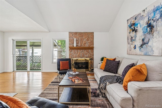 living room featuring hardwood / wood-style flooring, lofted ceiling, and a fireplace