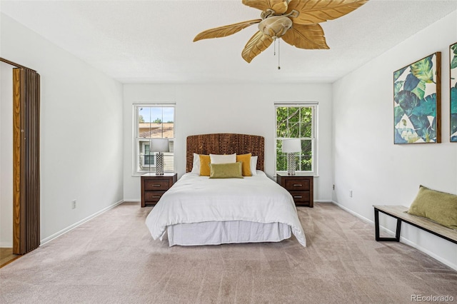 bedroom with multiple windows, light colored carpet, and ceiling fan