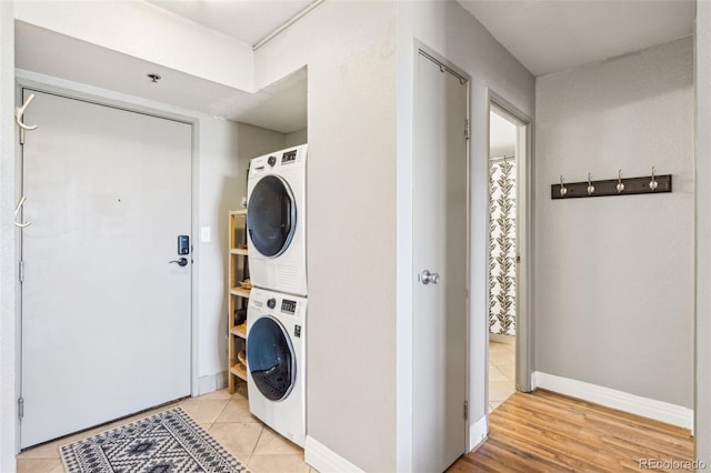 laundry room with stacked washer / drying machine and light tile patterned floors