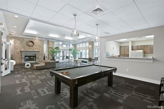 game room with dark colored carpet, a stone fireplace, a paneled ceiling, and billiards