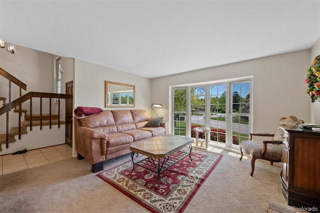 living area with light carpet and stairway