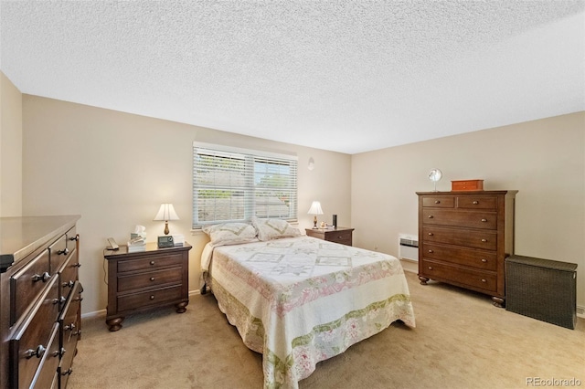 bedroom featuring light colored carpet, a textured ceiling, and baseboards