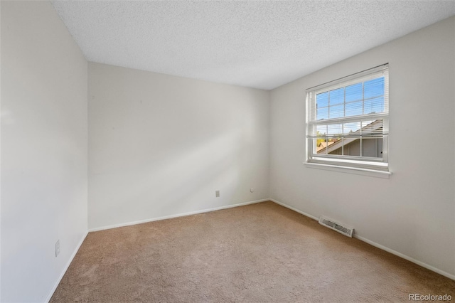 unfurnished room featuring carpet floors, a textured ceiling, and baseboards