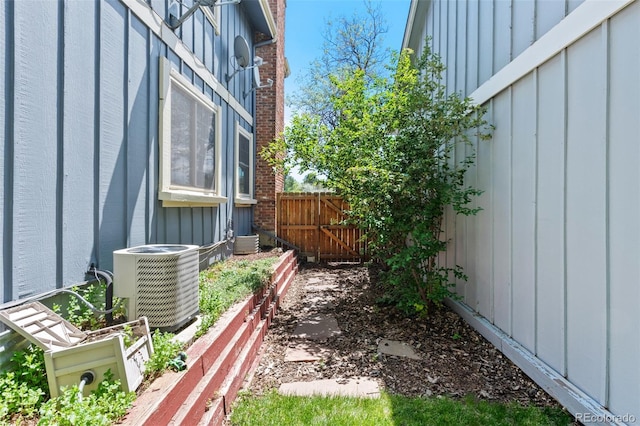 view of yard with central AC and fence
