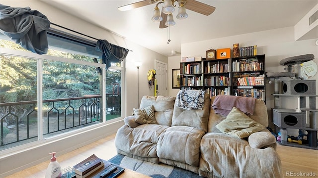 living room featuring ceiling fan and light hardwood / wood-style flooring