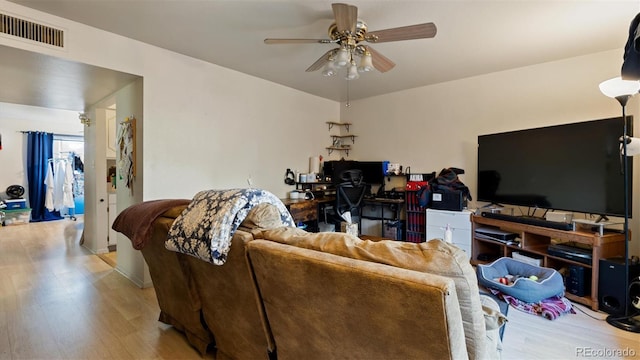 living room featuring ceiling fan and light hardwood / wood-style flooring