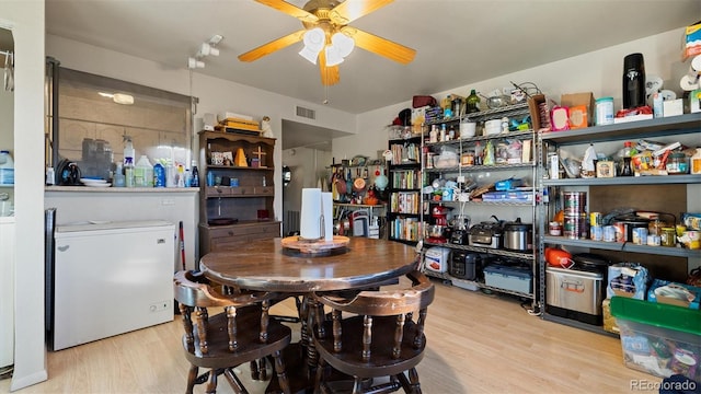 dining space featuring ceiling fan and light wood-type flooring