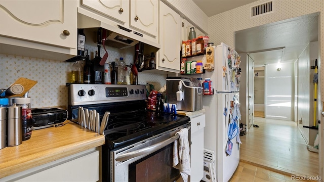 kitchen with electric range, light hardwood / wood-style floors, and white cabinetry