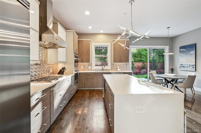 445 Forest St, Denver, CO 80220 - kitchen with appliances with stainless steel finishes, wall chimney exhaust hood, light countertops, dark wood finished floors, and recessed lighting