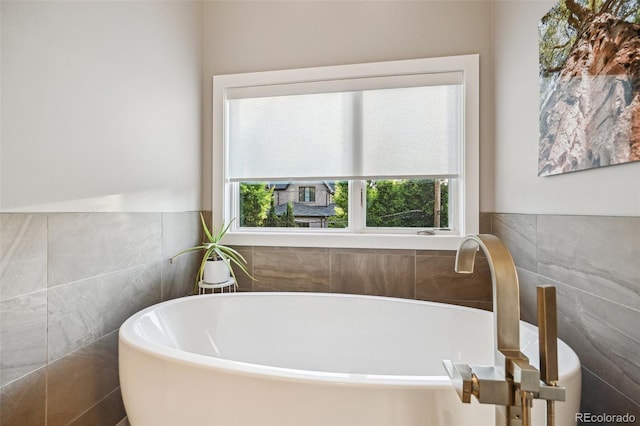 445 Forest St, Denver, CO 80220 - bathroom featuring tile walls, a freestanding tub, and healthy amount of natural light