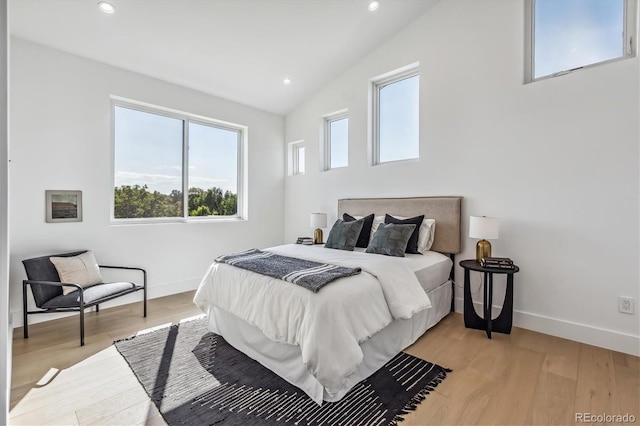 bedroom with recessed lighting, light wood-style flooring, baseboards, and lofted ceiling
