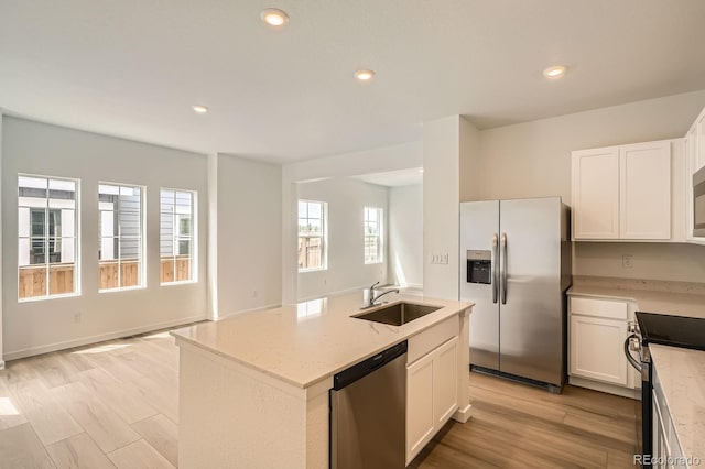 15228 Detroit St, Thornton, CO 80602 - kitchen with stainless steel appliances, white cabinets, light stone counters, recessed lighting, and a kitchen island with sink