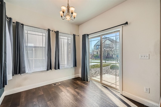 5624 Killdeer St, Brighton, CO 80601 - spare room featuring baseboards, a chandelier, and dark wood-type flooring