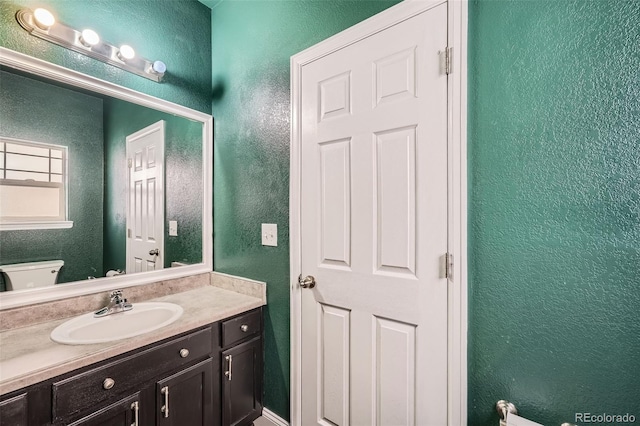 5624 Killdeer St, Brighton, CO 80601 - half bath featuring a textured wall, vanity, and toilet