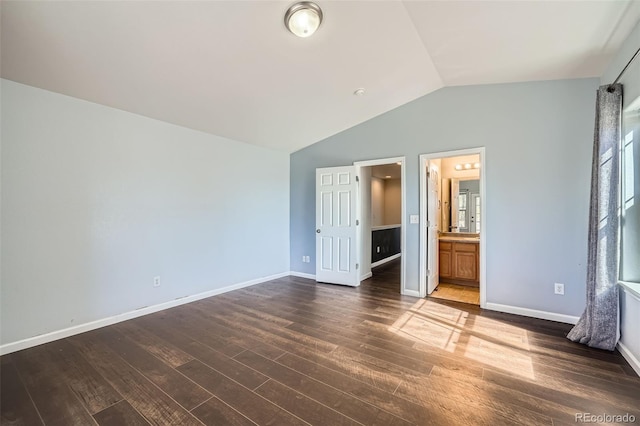 5624 Killdeer St, Brighton, CO 80601 - unfurnished bedroom with lofted ceiling, dark wood-style flooring, baseboards, and ensuite bathroom