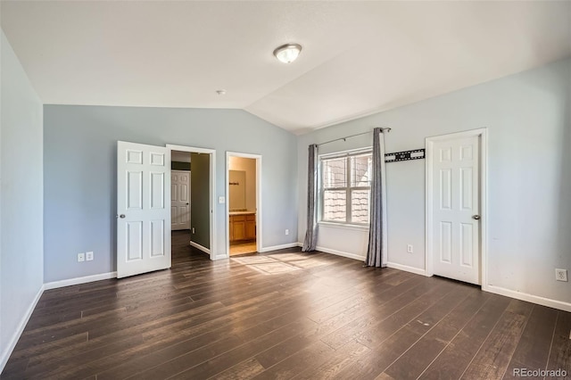 5624 Killdeer St, Brighton, CO 80601 - unfurnished bedroom with vaulted ceiling, dark wood-style flooring, baseboards, and ensuite bath