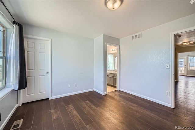 5624 Killdeer St, Brighton, CO 80601 - unfurnished bedroom with dark wood finished floors, baseboards, and ensuite bathroom