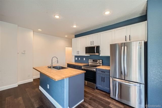 5624 Killdeer St, Brighton, CO 80601 - kitchen with wood counters, stainless steel appliances, a sink, dark wood-type flooring, and a kitchen island with sink