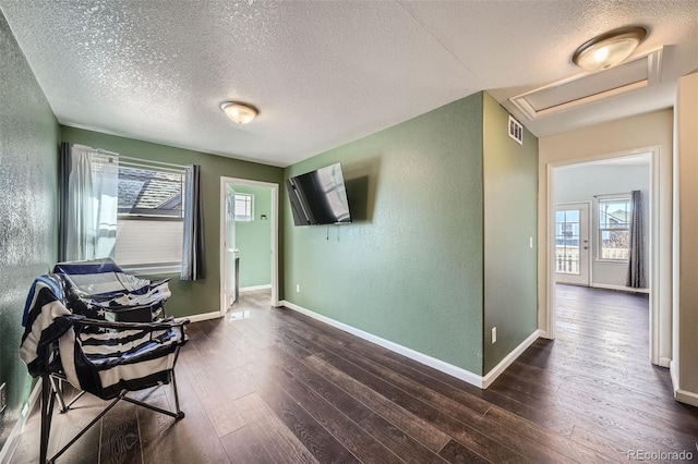 5624 Killdeer St, Brighton, CO 80601 - sitting room with a textured wall, a textured ceiling, dark wood-style floors, attic access, and baseboards