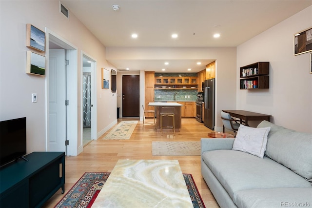 living area featuring recessed lighting, light wood-style floors, visible vents, and baseboards