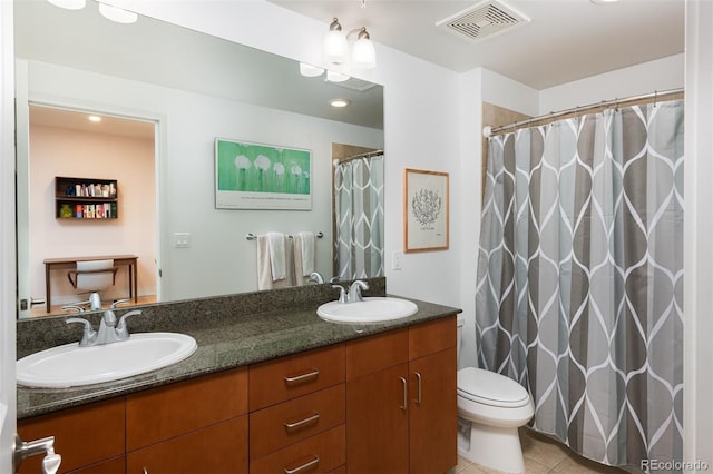 full bath with a sink, visible vents, double vanity, and tile patterned floors