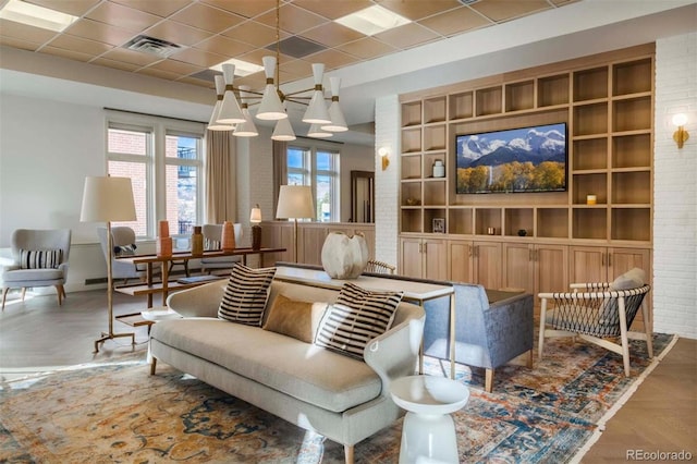 sitting room with visible vents, brick wall, and a paneled ceiling