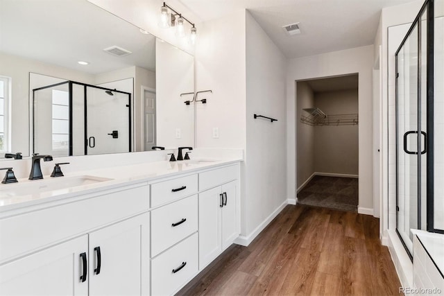 bathroom featuring vanity, an enclosed shower, and wood-type flooring