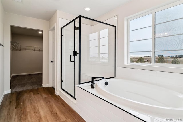 bathroom with wood-type flooring and plus walk in shower