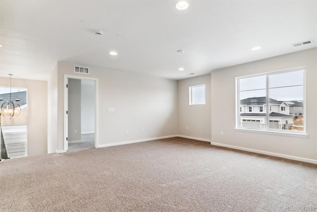 empty room featuring carpet flooring and an inviting chandelier