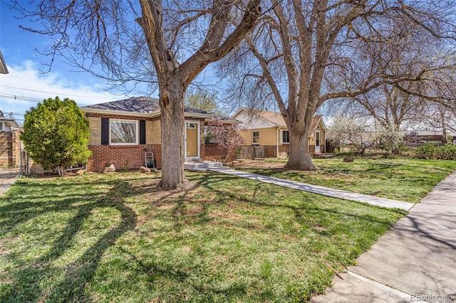 view of front of property with fence, a front yard, and brick siding