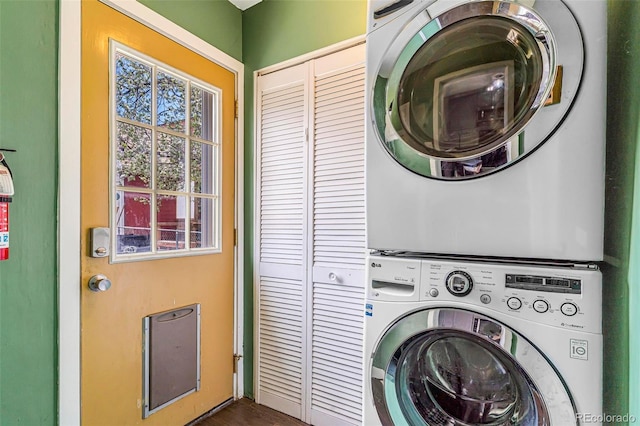 laundry room featuring laundry area, stacked washing maching and dryer, and a wealth of natural light