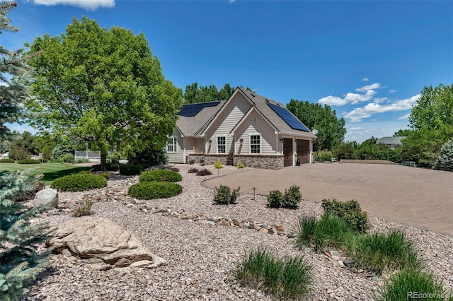 6633 E 166th Pl, Brighton, CO 80602 - view of front of home with solar panels, decorative driveway, a garage, and stone siding