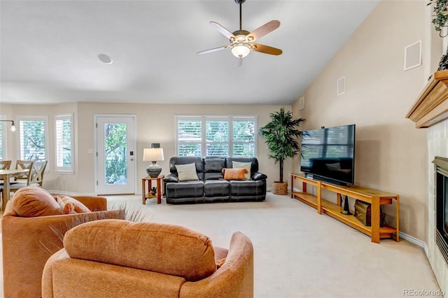 6633 E 166th Pl, Brighton, CO 80602 - carpeted living room with a ceiling fan, a glass covered fireplace, baseboards, and lofted ceiling