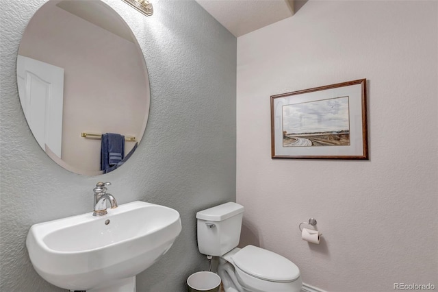 6633 E 166th Pl, Brighton, CO 80602 - half bath featuring a sink, toilet, and a textured wall