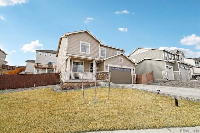 view of front facade with a front lawn, fence, concrete driveway, covered porch, and a garage