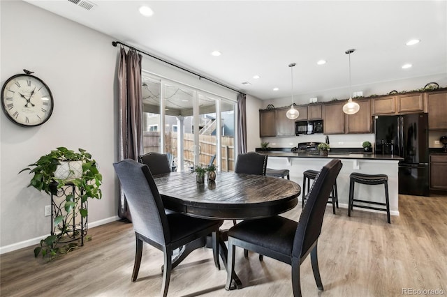 dining space featuring recessed lighting, baseboards, and light wood finished floors