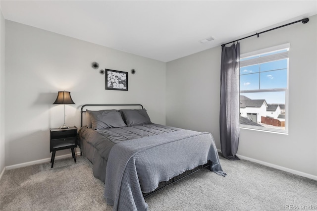 carpeted bedroom with visible vents and baseboards