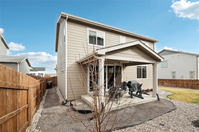 rear view of property with a patio and a fenced backyard