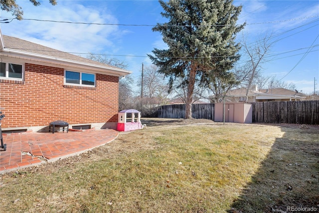 view of yard with a storage shed, a fire pit, and a patio area