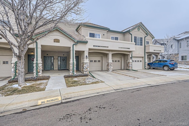 view of property featuring driveway, an attached garage, and stucco siding