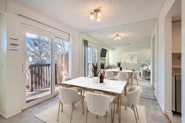 dining space featuring light colored carpet and a textured ceiling