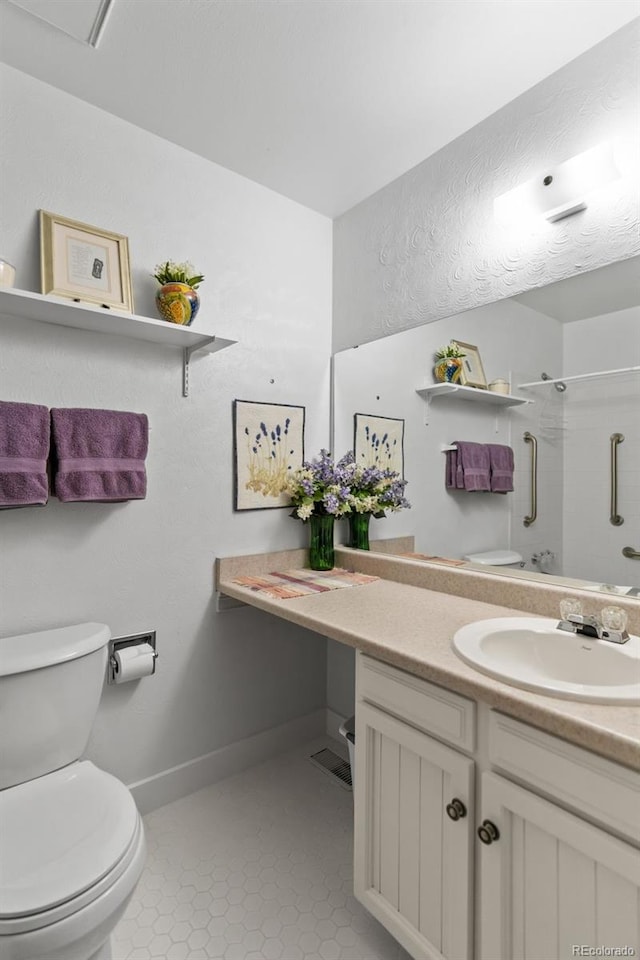 bathroom featuring vanity, toilet, tile patterned flooring, and a shower