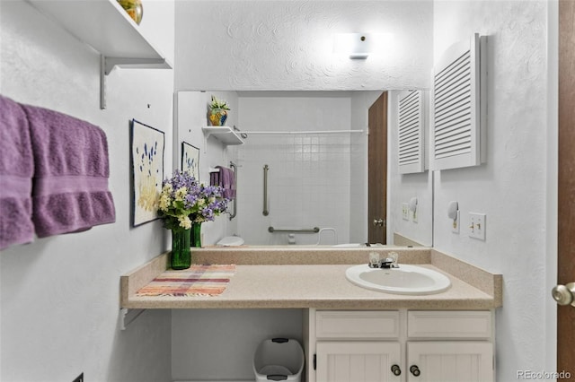 bathroom with vanity and tiled shower