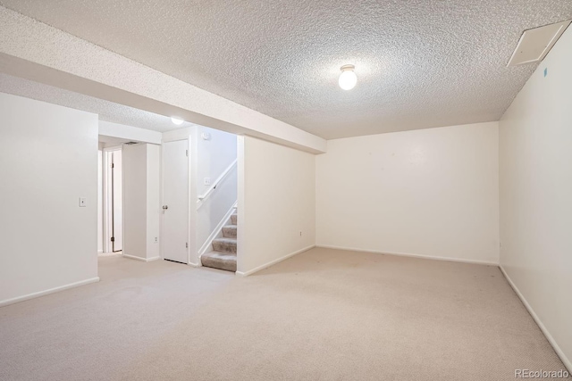 basement with light colored carpet and a textured ceiling