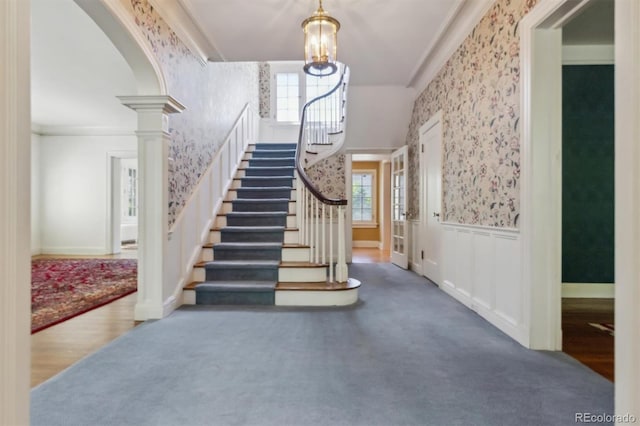 2222 E 7th Avenue Parkway, Denver, CO 80206 - staircase featuring wallpapered walls, carpet flooring, plenty of natural light, a wainscoted wall, and arched walkways