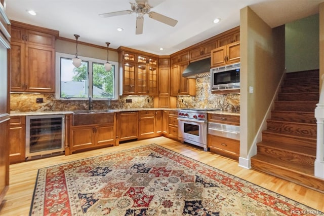 2222 E 7th Avenue Parkway, Denver, CO 80206 - kitchen featuring stainless steel appliances, beverage cooler, a sink, under cabinet range hood, and light wood finished floors