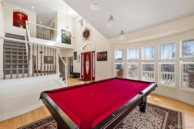 rec room featuring a towering ceiling, billiards, baseboards, and wood finished floors