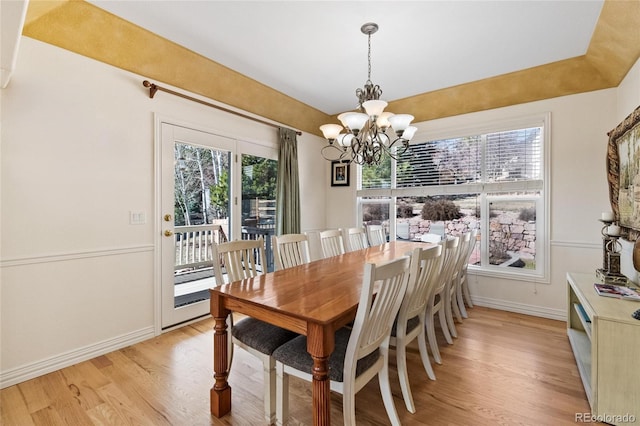 dining space featuring light wood-type flooring, baseboards, and a chandelier